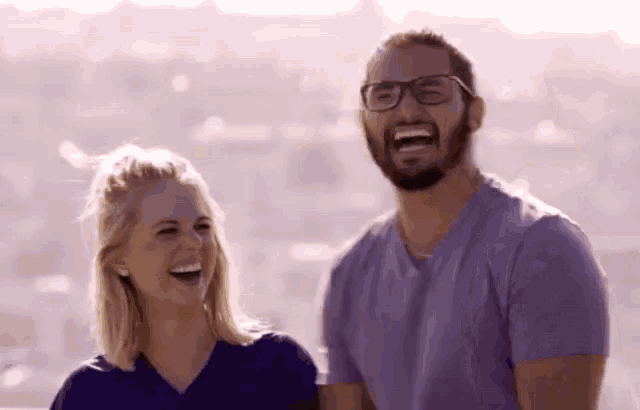 a man and a woman are laughing together and the woman is wearing glasses