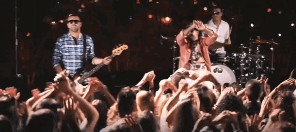a man playing a guitar in front of a crowd with a drum that says dw on it