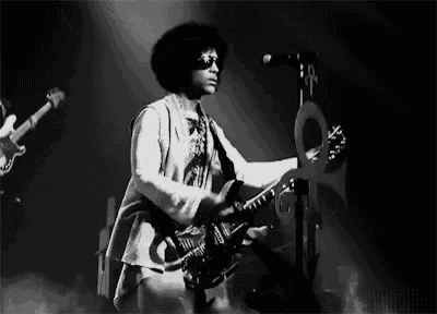 a man is playing a guitar and singing into a microphone on stage .