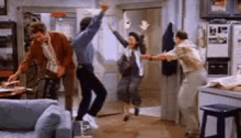 a group of people are dancing in a living room in front of a refrigerator .