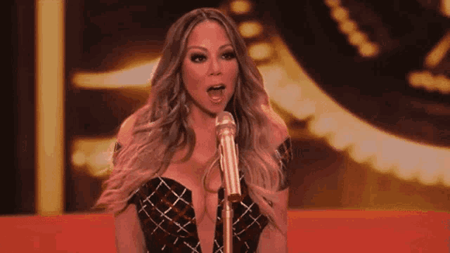 a woman in a plaid dress is singing into a microphone .