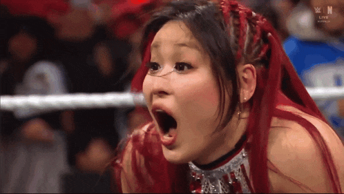 a woman with red hair is making a funny face in front of a sign that says win