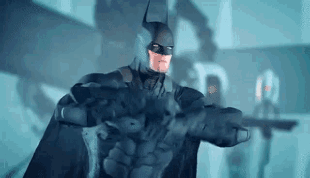 a man in a batman suit is holding a gun in a dark room .