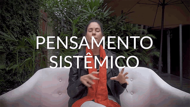 a woman sits on a couch with the words " pensamento sistemico " on the bottom