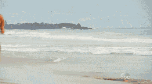 a shirtless man is running on the beach without a shirt .