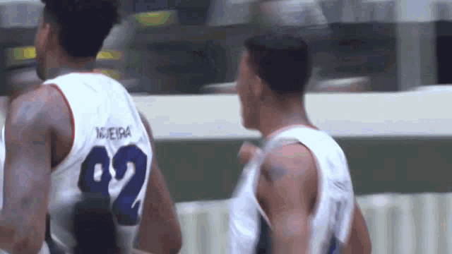 a basketball player wearing a number 02 jersey stands next to another player