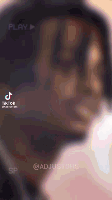 a blurred image of a man 's face with a play button in the background