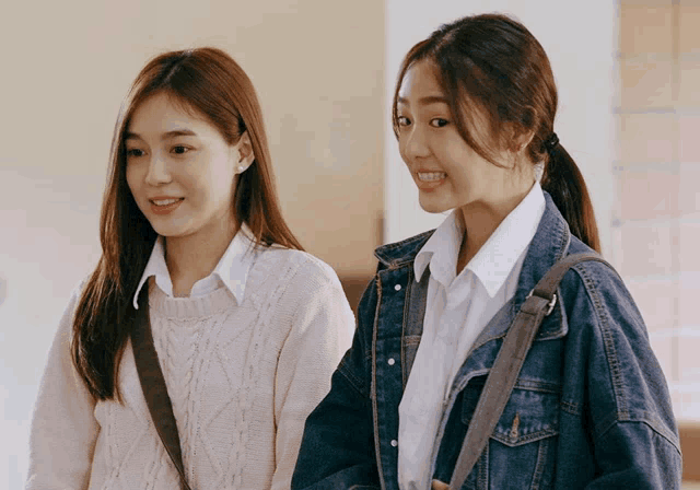 two girls are standing next to each other and smiling for the camera