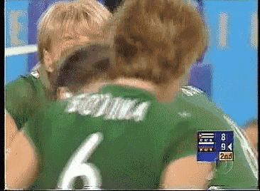 a man in a green jersey with the number 6 hugging another man