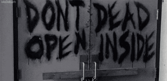 a sign that says " do n't dead open inside " is spray painted on a door