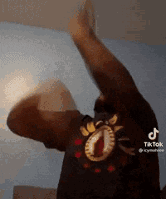 a man wearing a black shirt with a cat on it is dancing .