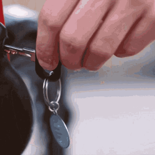 a person is holding a key with a blue tag that says x