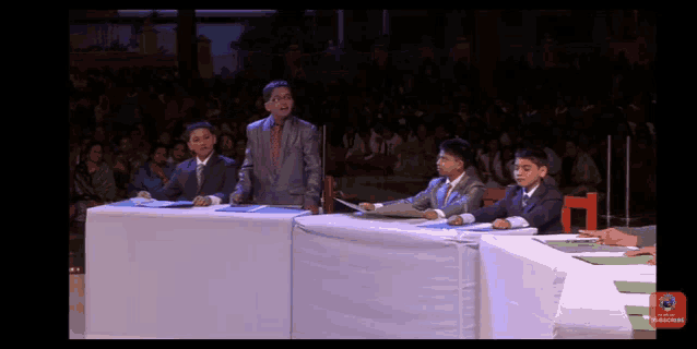 a group of people sitting at a table with a subscribe button on the bottom