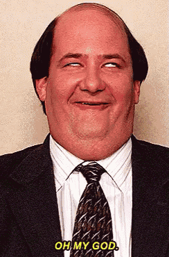 a bald man in a suit and tie is making a funny face and says oh my god
