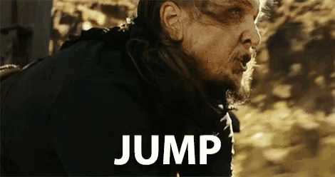 a man with a beard is jumping in the air with the word jump behind him .