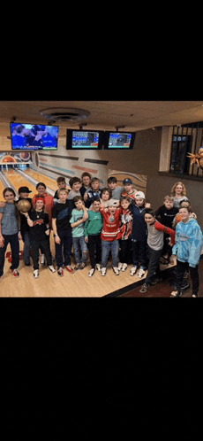 a group of boys are posing for a picture in a bowling alley