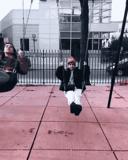two people are swinging in front of a building that has the number 486 on it