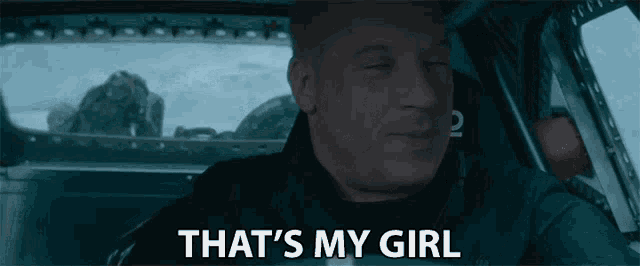 a man is sitting in the driver 's seat of a car and says `` that 's my girl '' .