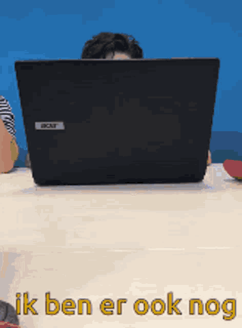 a man sitting in front of an acer laptop computer