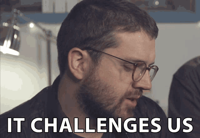 a man with glasses and a beard says " it challenges us "