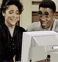 a man and a woman are looking at a computer monitor