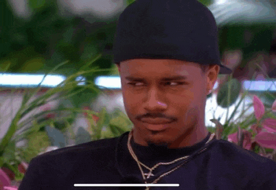 a man wearing a hat and a necklace is looking at something