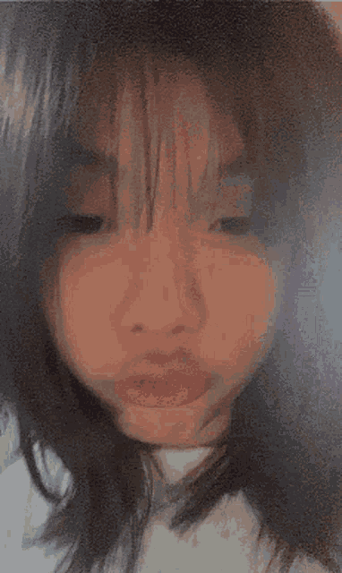 a close up of a girl 's face with a white spot on her face .