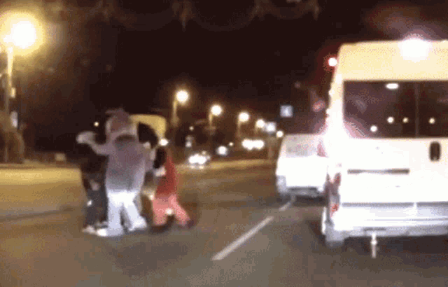 a white van is parked in a parking lot next to a group of people in costumes
