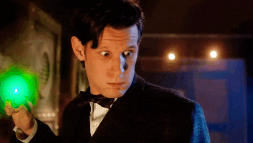 a man in a tuxedo is holding a green light