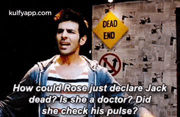 a man is standing in front of a dead end sign and talking to another man .