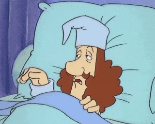 a cartoon character is laying in bed with a sleep cap on his head
