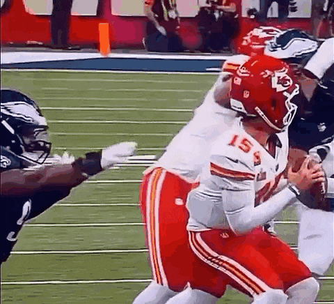 a football player is being tackled by another player on the field while holding a football .