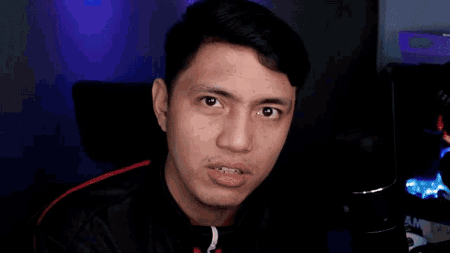 a young man is making a funny face while sitting in a chair .