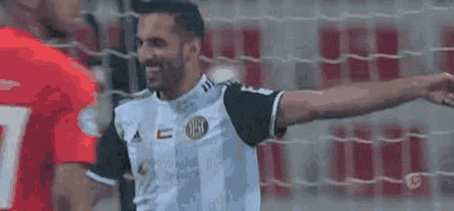 a soccer player is standing in front of a soccer net .