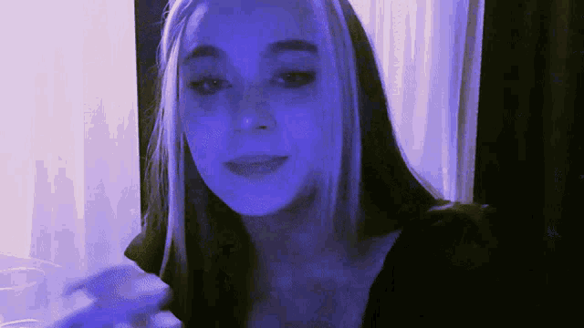 a woman with blue hair is looking at the camera