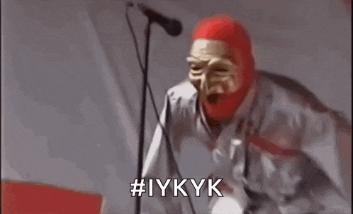a man wearing a red mask is making a funny face and screaming .