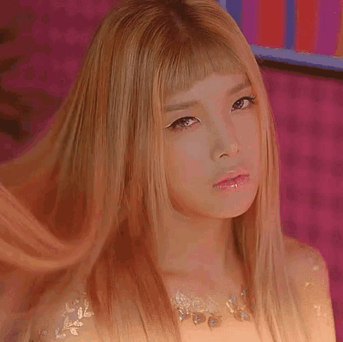 a close up of a woman with long blonde hair and a piercing in her lip