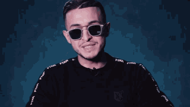 a man wearing sunglasses and a black shirt that says firn
