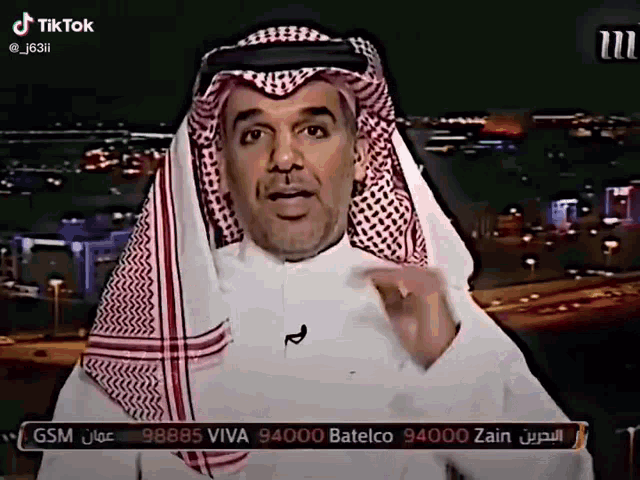 a man in a keffiyeh is talking on a tv screen with the number 94000 zain on the bottom