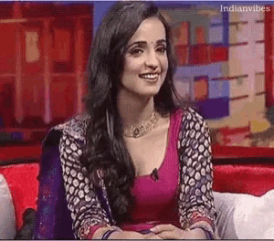 a woman sitting on a couch with indianvibes written on the bottom right