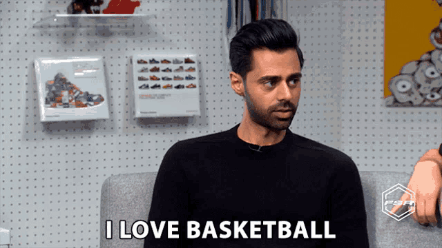 a man is sitting on a couch and says i love basketball