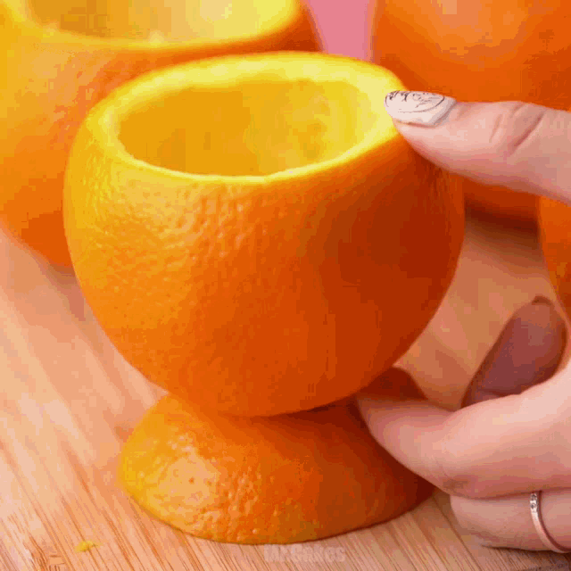 a person is holding an orange with a hole in it