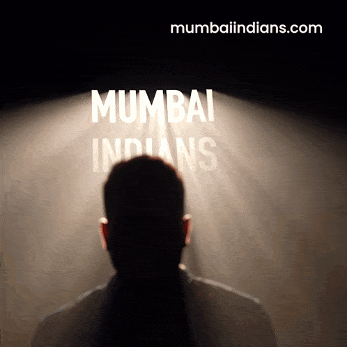 a man stands in front of a spotlight that says mumbai indians