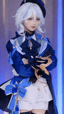 a woman in a blue and white costume with white hair is standing with her arms crossed