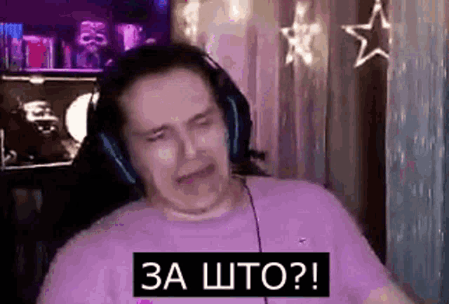 a man wearing headphones is crying while sitting in front of a computer .