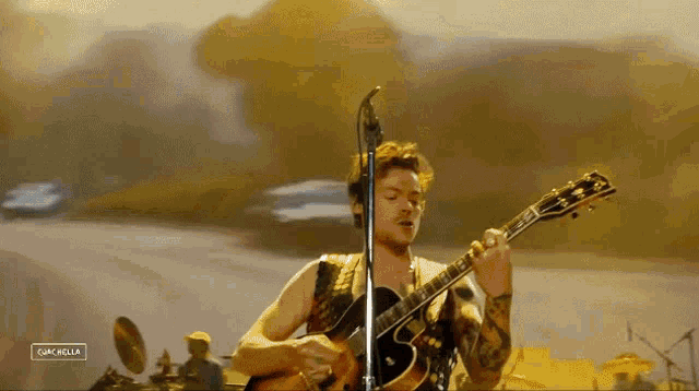 a man is playing a guitar and singing into a microphone with a watermark that says cancel hella