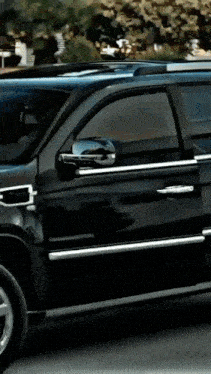 a black suv is parked in front of a building