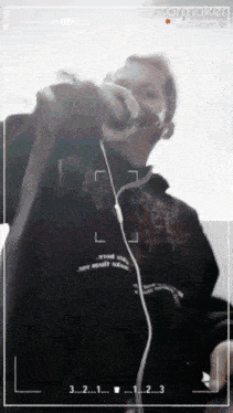 a person wearing headphones and a black hoodie is being recorded on a camera