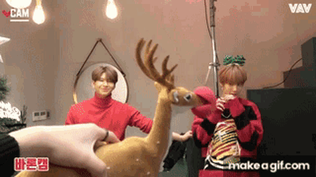 a person is holding a stuffed reindeer in front of a mirror