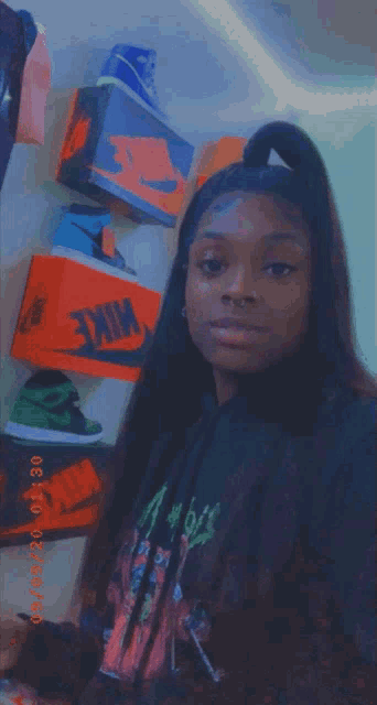a woman is standing in front of a wall of nike shoes